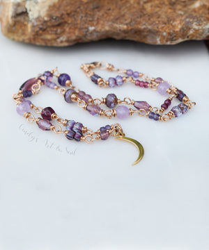 crescent moon necklace with golden bronze metal. Beaded chain with beads in various shades of purple.