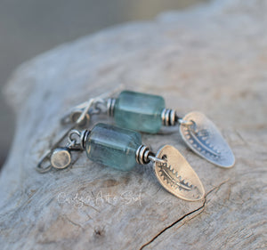 Blue glass beads with silver and gold accents on a wooden surface, featuring 'Candys Art & Soul' branding.