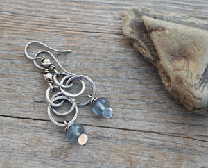 Silver earrings with blue beads on a wooden surface