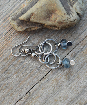 Silver earrings with blue beads on a wooden surface