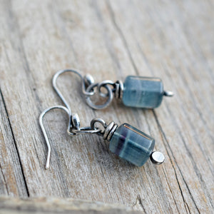 Pair of blue beaded earrings on a wooden surface