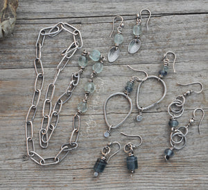 Silver jewelry set with beads on a wooden surface
