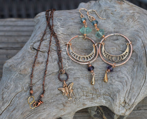 Jewelry set including a necklace and earrings on a textured stone surface