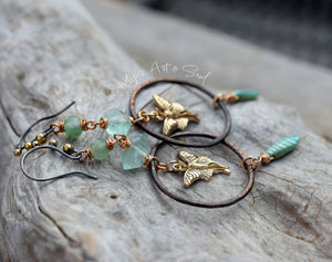 Jewelry set with butterfly charms and green beads on a stone surface