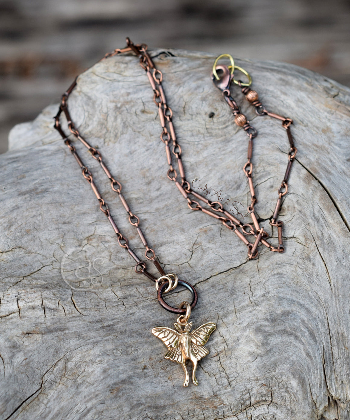 Copper fairy pendant necklace on a textured stone surface