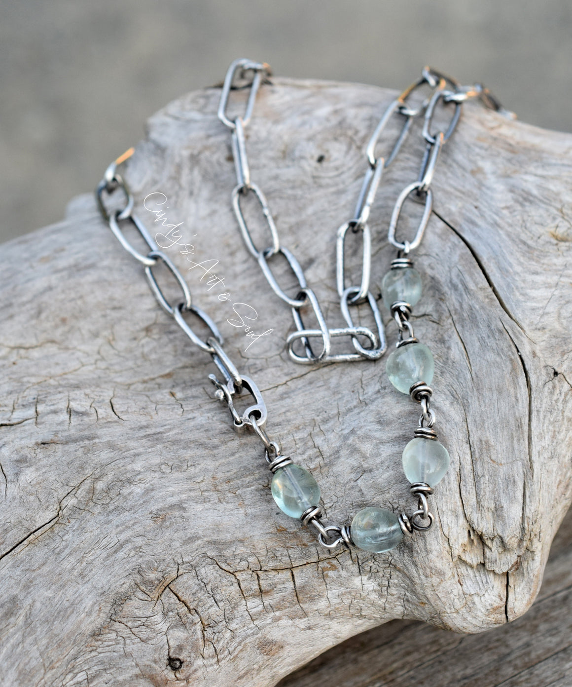 Necklace with green beads on a piece of driftwood