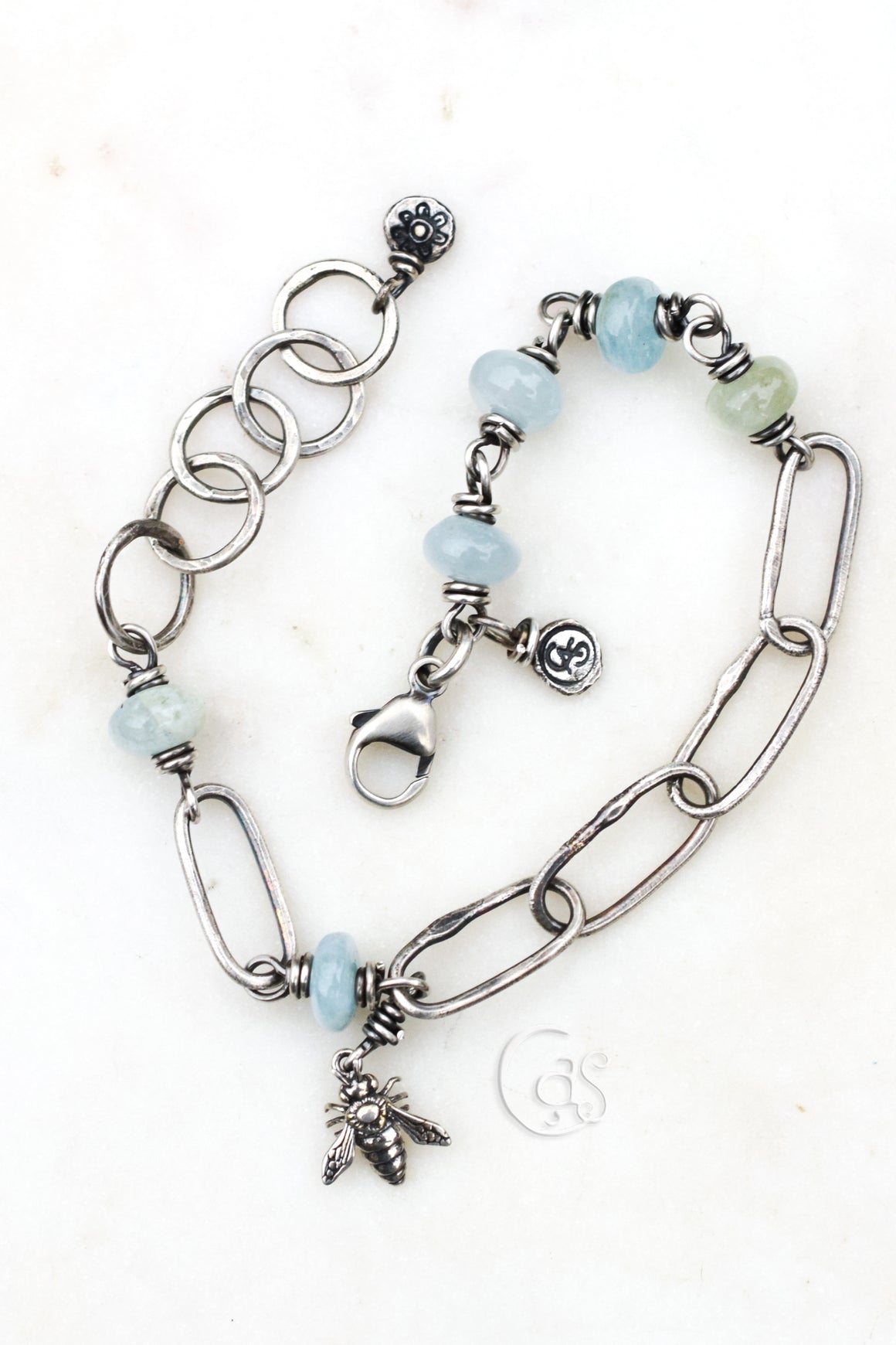 Silver bracelet with chain and beaded design on a white background