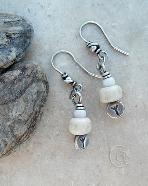 These earrings are built around Silver nugget headpins with the Algiz Rune. Handcrafted from .999 pure, raw silver and hand stamped with the tiny 3mm runes. Each one is unique and rustic in appearance.  Adorned with handcrafted porcelain beads in creamy off white, paired with rustic white African glass beads.  This little bead totem hangs from a small silver ring which attaches to the ear wires. This center ring gives the charms a nice movement.  The ear-wires are crafted from .925 sterling silver. Always. 
