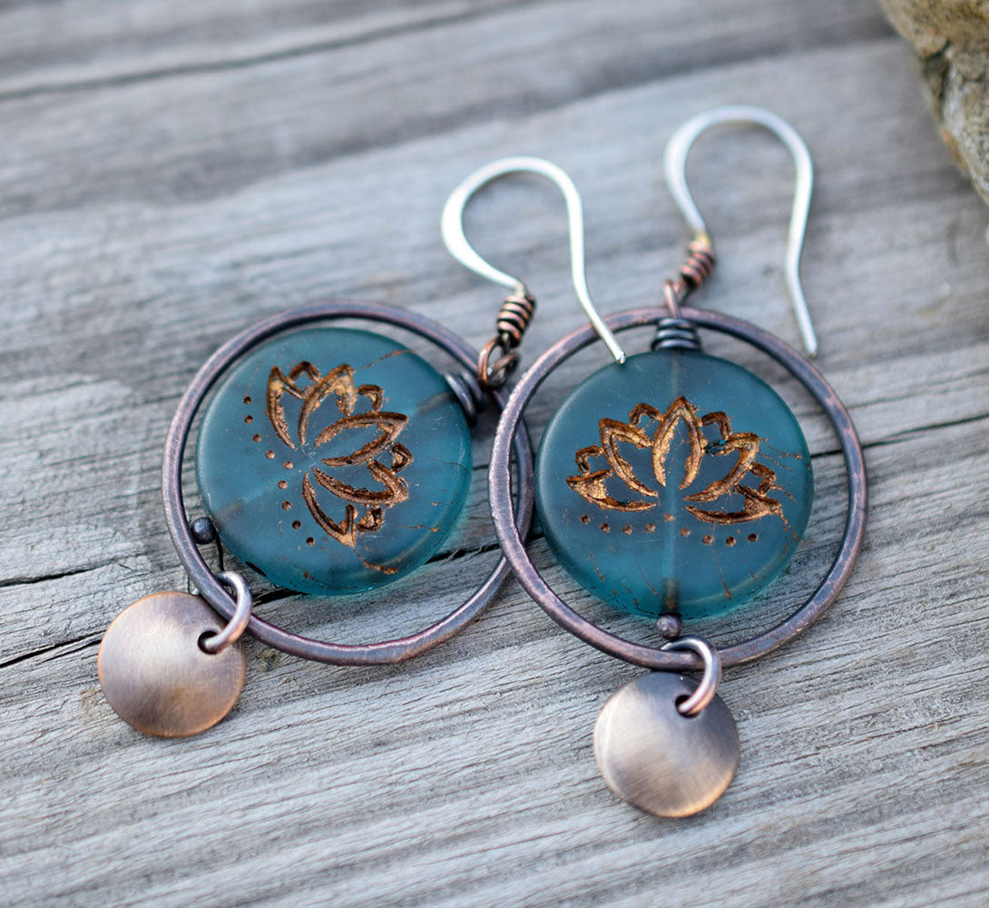 Copper hoop earrings with blue glass lotus beads at the center with golden highlights. Brass circle dangles. Bohemian Style Earrings that are handmade.