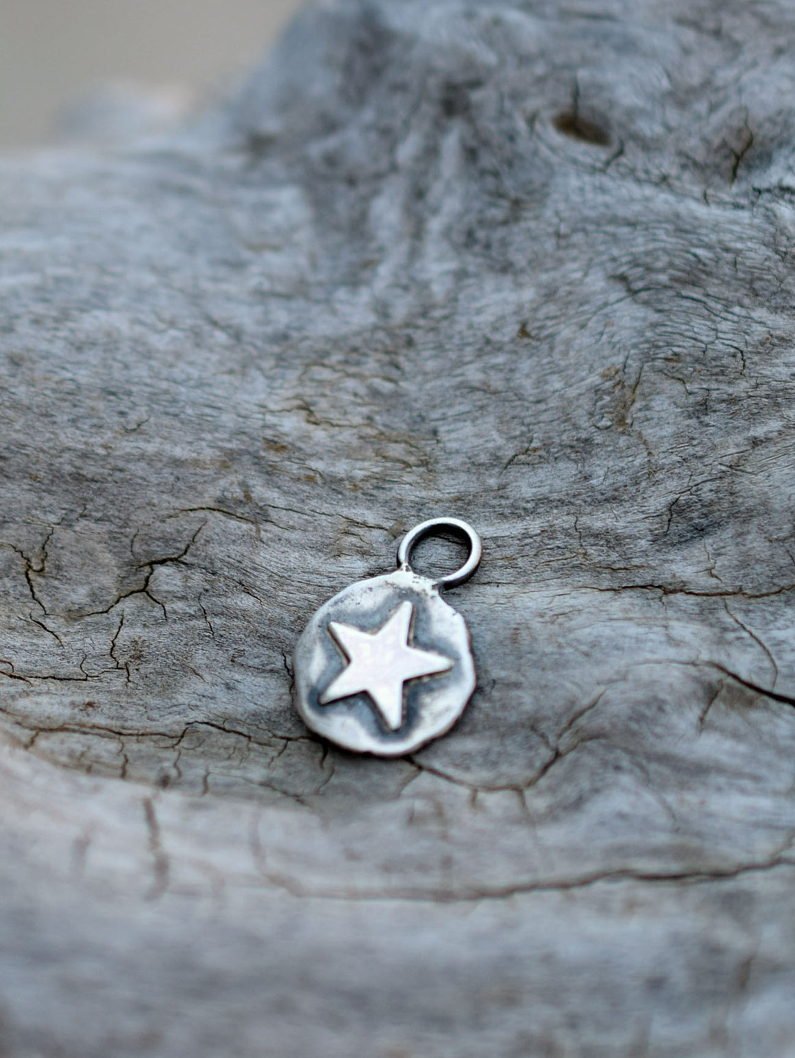 silver star charm on a wood background